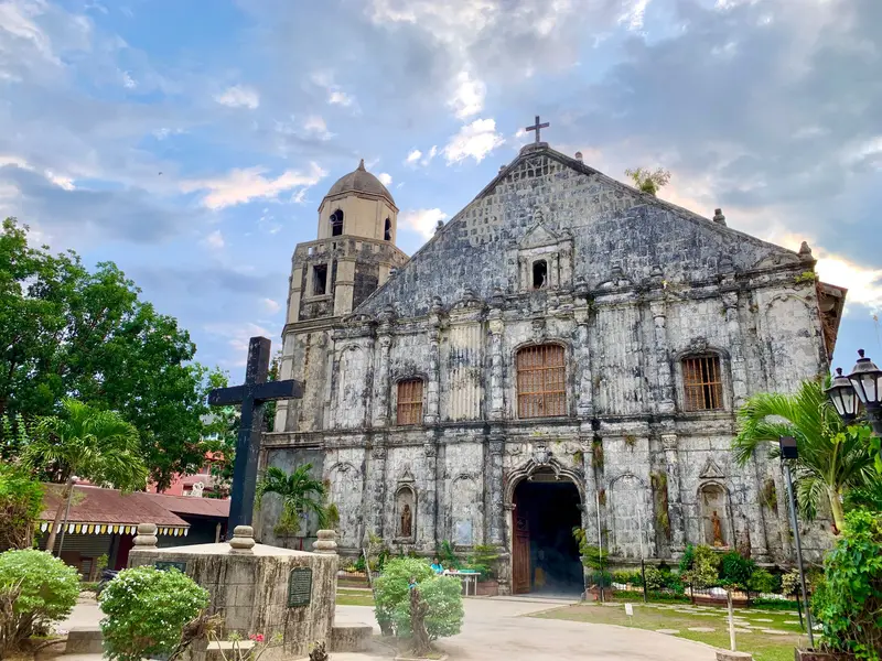 Weathered coral-stone facade and bell tower of Sts. Peter and Paul Church, Bantayan town, Cebu