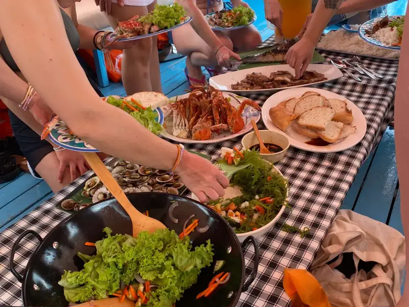 Guests serving a lunch of crab, clams, grilled fish and salad on board the boat
