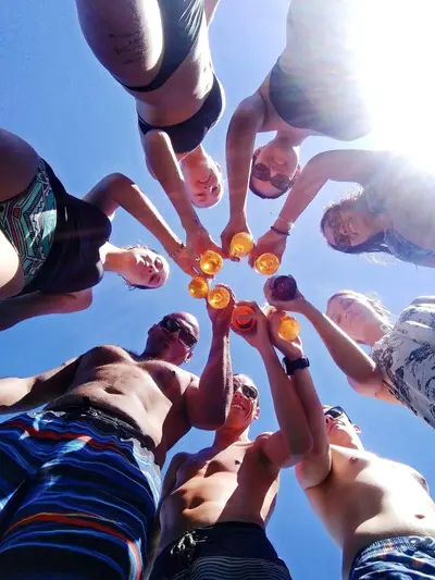Tour group raising their drinks in a toast on Carnaza Island, seen from below