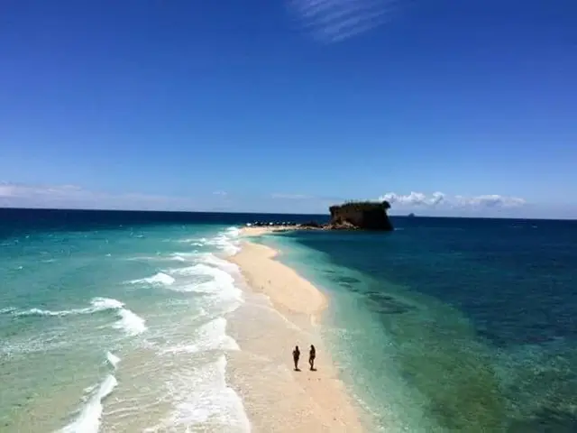 Two guests on Lamanoc Island's long white sandbar, with a rocky islet at its tip