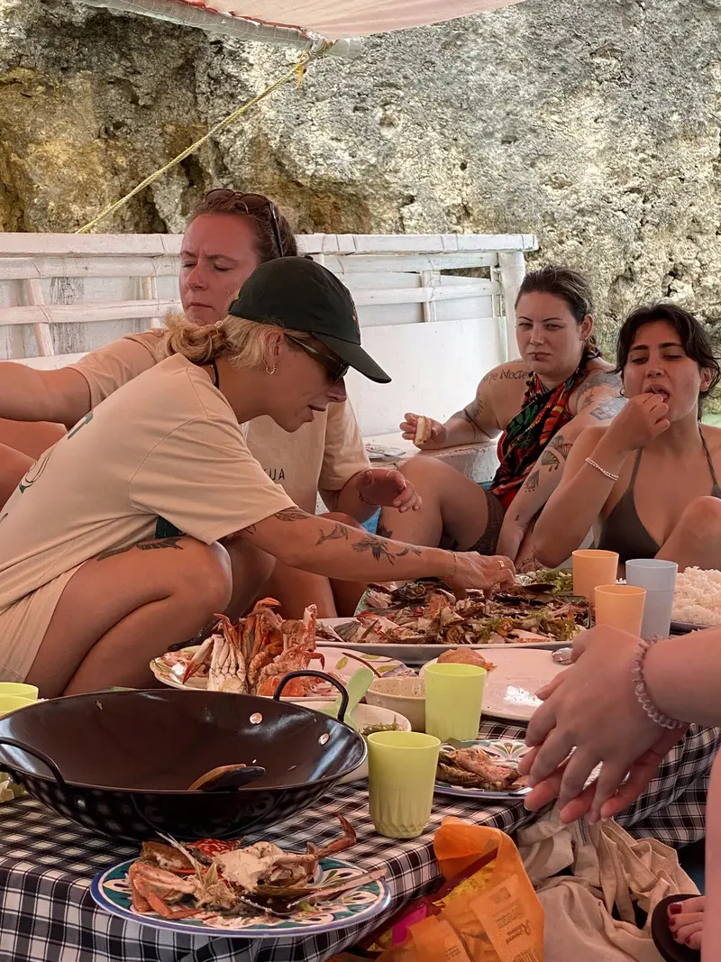 Guests sharing a fresh seafood BBQ of crab and grilled fish aboard the boat